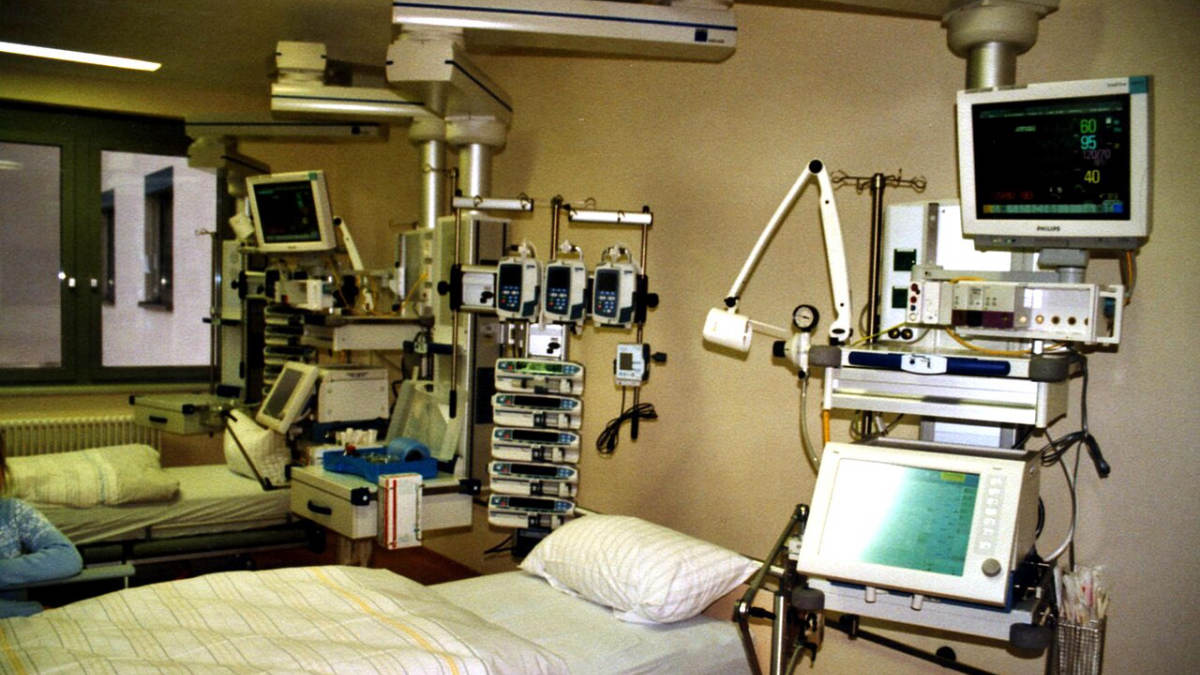 Lůžko na jednotce intenzivní péče s monitory a infuzními pumpami