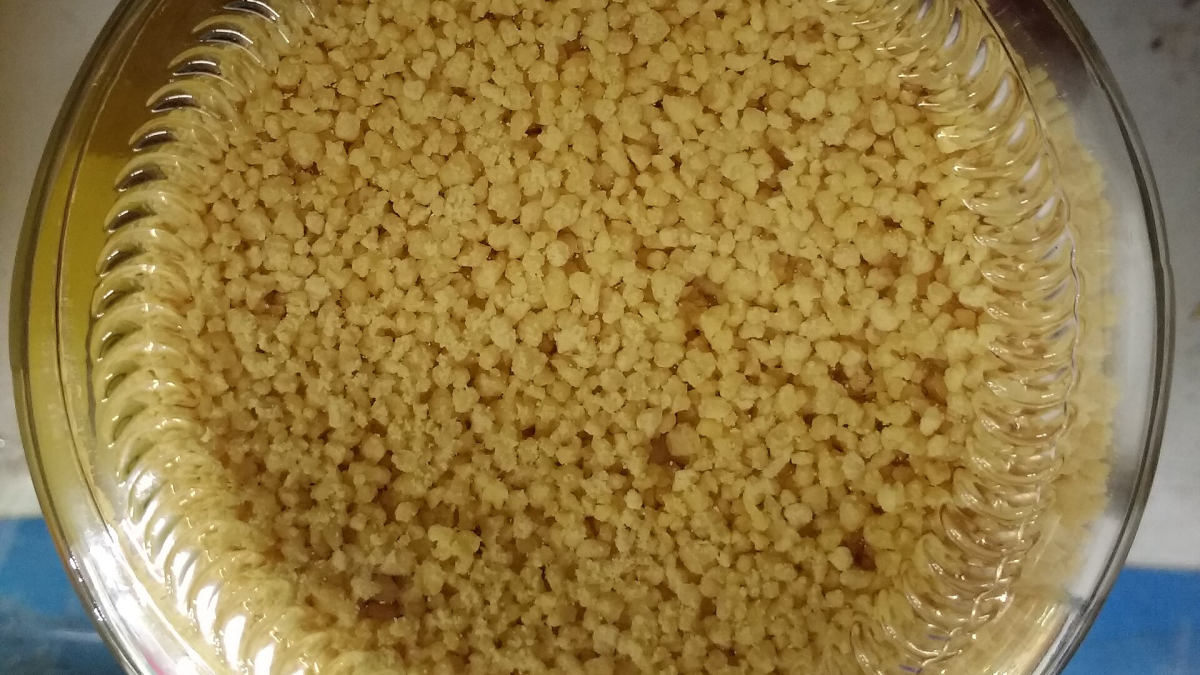 Žluté granule sójového lecitinu ve skleněné dóze, pohled shora