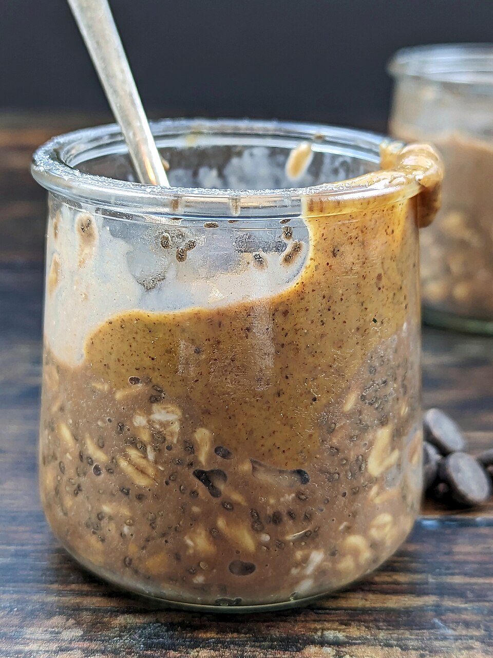 Proteinová ovesná kaše ve sklenici s ořechovým máslem a chia semínky